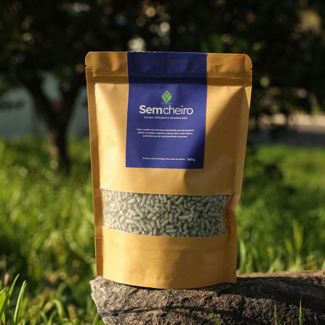 Adubo orgânico Sem Cheiro 500g em embalagem kraft sobre pedra em jardim ao ar livre